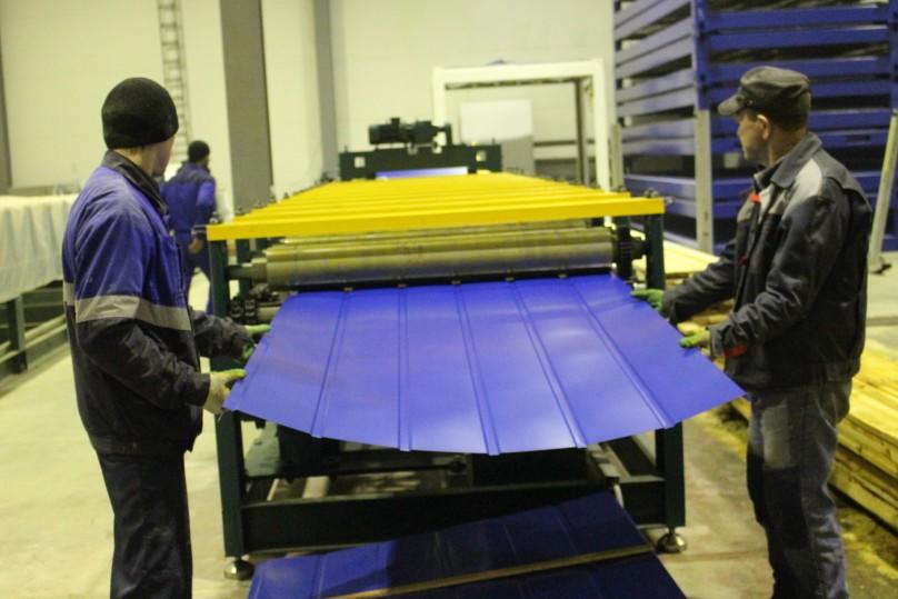 Операторы станка вручную принимают готовый лист, выходящий из последней клети.